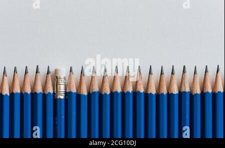 Row of tops of many new sharpened blue pencils against white paper. Stock Photo