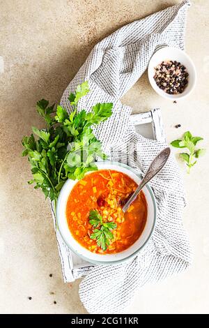 Hot and spicy, thick lentil and red bean soup with canned tomatoes and coriander. Concrete background, selective focus. Stock Photo