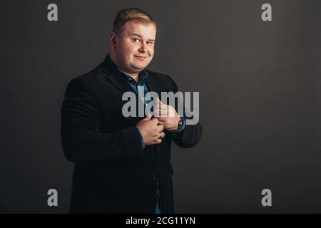 Plus size businessman in black suit on black background Stock Photo