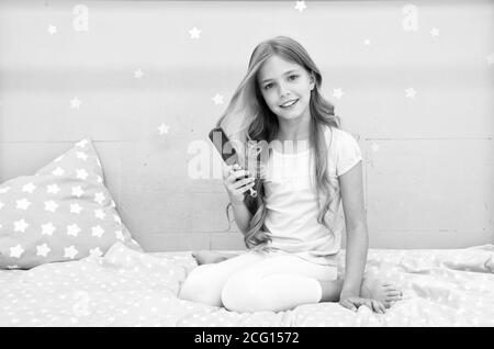 Relaxing hair brushing. Happy child hold hair brush. Brushing before and after bed. Haircare and styling. Untangling or brushing. Brushing hair stimulates its grows. Stock Photo