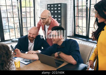 Shot of a group of young business professionals having a meeting. Diverse group of young designers smiling during a meeting at the office.