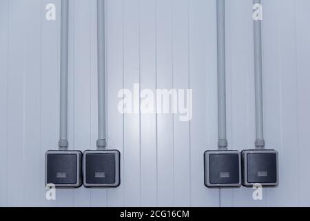 The waterproof light switch is mounted on the sandwich panel wall. Electrical equipment in a production building. Stock Photo
