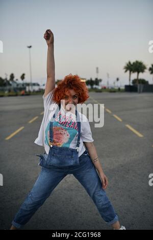 Young happy redhead girl dancing in the street Stock Photo