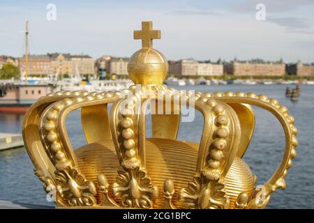 Royal symbol Sweden, a painted gold crown on Skeppsholmbron Stockholm on sunny day. Stock Photo