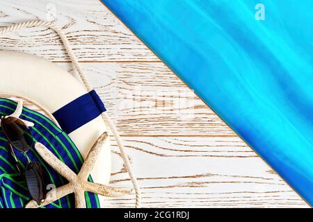 Beach accessories set, including hat, sunglasses, lifebuoy on the wooden surface. Flat lay design of vacation equipment with the copy space Stock Photo