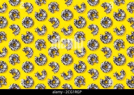 donuts on a yellow background top view. Flat lay of delicious nibbled chocolate donuts. used as donut banner or poster background, not pattern. Stock Photo