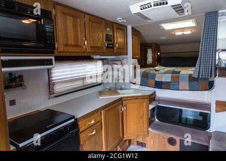 Interior of an Artic Fox truck camper showing the ktichen and over-cab queen bed. Stock Photo