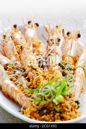 Fried shrimps on a plate topping with minced garlic Stock Photo