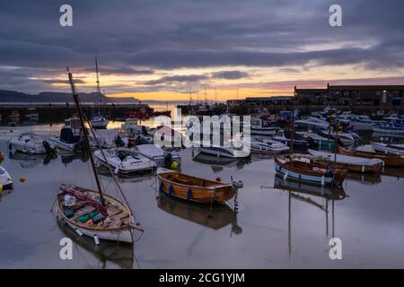 Lyme Regis, Dorset, UK. 9th Sep, 2020. UK Weather: The sun breaks through cloud over the Cobb at Lyme Regis after a rather moody start to the day. Credit: Celia McMahon/Alamy Live News Stock Photo