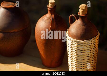 brown earthenware dishes are on a wooden shelf. in the bright summer sun Stock Photo