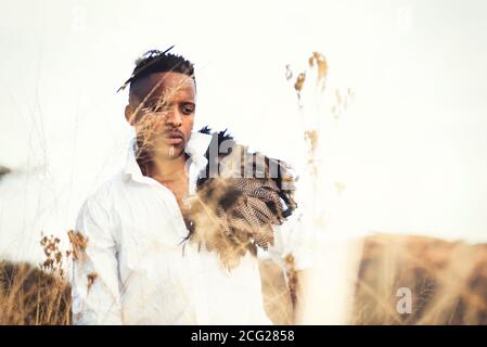 african gentleman in the african bush with bush hat in the grass Stock Photo