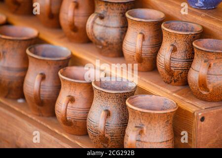 brown clay pots stand on a wooden shelf Stock Photo