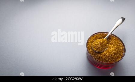 Brown sugar with bowl and spoon on background for text Stock Photo
