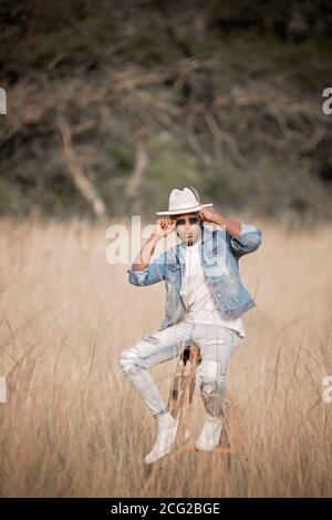 african gentleman in the african bush wearing a hat and sun glasses in the bright sun Stock Photo