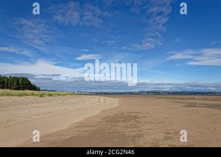 The wide expanse of sand at low tide at the Tentsmuir Nature Reserve on the Tay Estuary, with the City of Dundee in the background Stock Photo