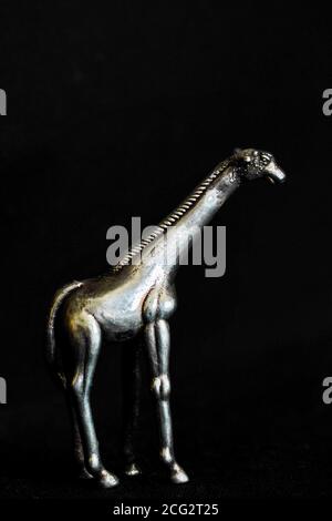 Giraffe statuette on black background Stock Photo