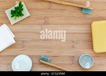 Zero waste bathroom backdrop with copy space. Bamboo toothbrushes, solid toothpaste, solid shampoo and soap on wood background. Plastic free, environm Stock Photo