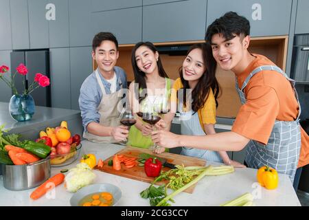 Happy young cook while drinking red wine Stock Photo