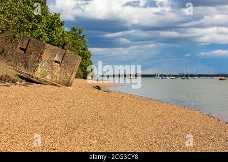 A WWII pill box on the banks of the River Medway at Upnor, the tide washed away its foundations causing it to tilt, Kent, UK Stock Photo