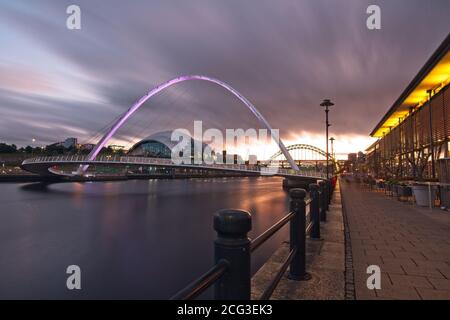 The Gateshead Millennium Bridge spanning the River Tyne captured at dusk from Newcastle quayside looking up the River Tyne.
