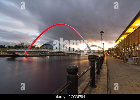 The Gateshead Millennium Bridge spanning the River Tyne captured at dusk from Newcastle quayside looking up the River Tyne.