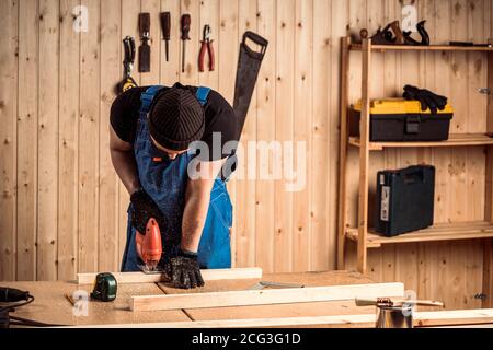 A carpenter using a jigsaw to cut wood cuts bars Stock Photo
