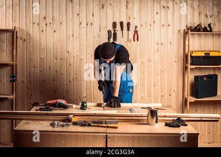 A carpenter using a jigsaw to cut wood cuts bars Stock Photo