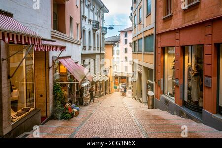 Lugano Switzerland , 1 July 2020 : Pedestrian Via Cattedrale sloped shopping street of Lugano with colorful houses in Ticino Switzerland Stock Photo