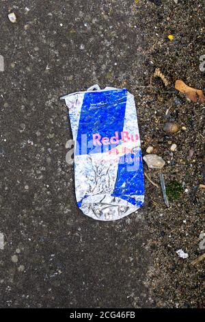 A squashed flat Red Bull energy drink can. Stock Photo