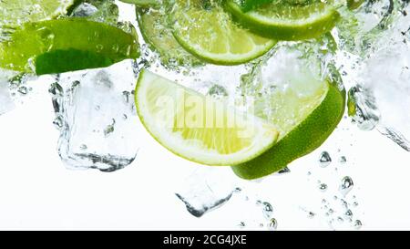 Lime Slices with ice cubes falling deeply under water isolated on white background Stock Photo