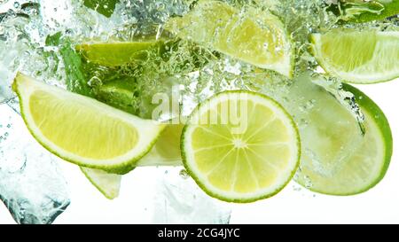 Lime Slices with ice cubes falling deeply under water isolated on white background Stock Photo