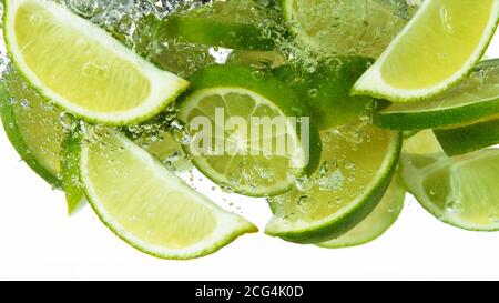 Lime Slices falling deeply under water isolated on white background Stock Photo