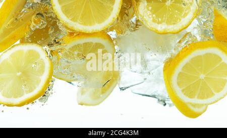 Lemon Slices with ice cubes falling deeply under water isolated on white background Stock Photo