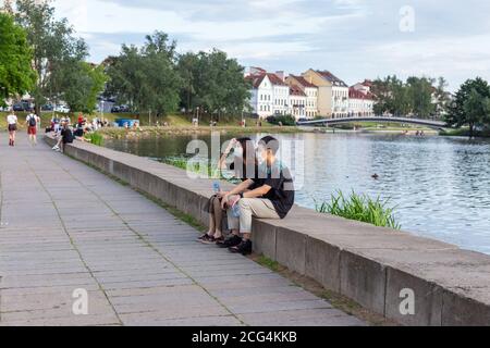 A guy and a girl in medical masks on the banks of the Svisloch River Stock Photo