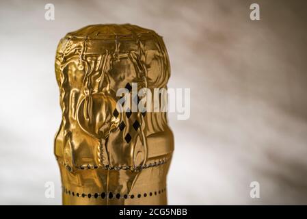 Close up of unopened bottle of champagne top, gold foil intact. Stock Photo