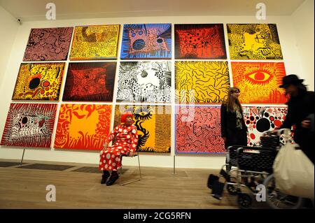 EDITORIAL USE ONLY Japanese artist Yayoi Kusama in front of her artwork, Love arrives at the Earth carrying it a tale of the Cosmos, at the Tate Modern, London.  Stock Photo