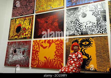 EDITORIAL USE ONLY Japanese artist Yayoi Kusama in front of her artwork, Love arrives at the Earth carrying it a tale of the Cosmos, at the Tate Modern, London.  Stock Photo
