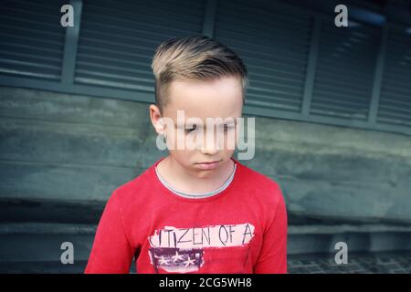 Cute little blue eyed caucasian blond boy looks sad and frustrated.He is looking with sorrow pensive expression in his face.Emotional expression face Stock Photo