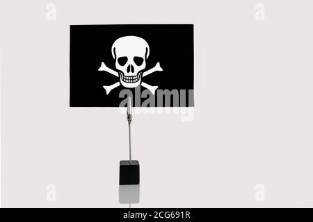 Jolly Roger Pirates flag in cube base in photograph holder on a white background Stock Photo