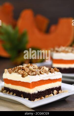 Pumpkin pie - light, creamy dessert with cheese cream and pumpkin layers topped with chopped nuts Stock Photo