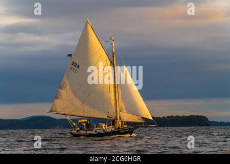 setting sun lights up the sails of sailboat on Lake Champlain, Burlington, Vermont Stock Photo