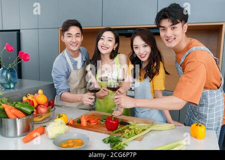 Happy young cook while drinking red wine Stock Photo