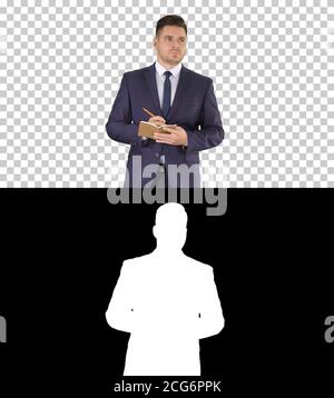 Handsome experienced manager writing in notebook his ideas while walking, Alpha Channel Stock Photo
