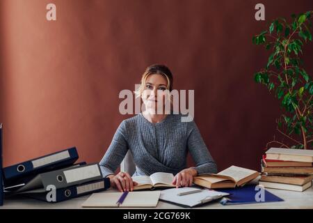 woman in business suit at work in office at a table with books and documents Stock Photo