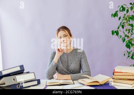 woman in business suit at work in office at a table with books and documents Stock Photo