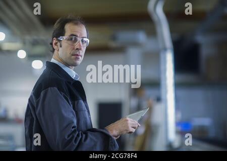 Engineer using a digital tablet in a factory, Germany Stock Photo