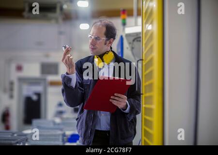 Engineer measuring a machine part in an industrial plant, Germany Stock Photo