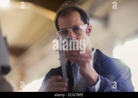 Engineer measuring a machine part in an industrial plant, Germany Stock Photo