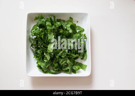Chopped spinach in a white dish Stock Photo