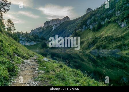 The mountain hut and the Alpstein mountain range reflecting on the Faelensee lake in the Swiss canton of Appenzell at sunrise Stock Photo